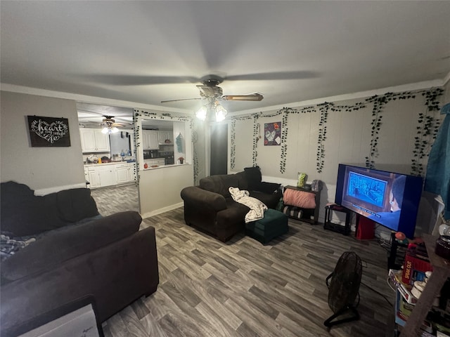 living room featuring hardwood / wood-style floors, ceiling fan, and ornamental molding