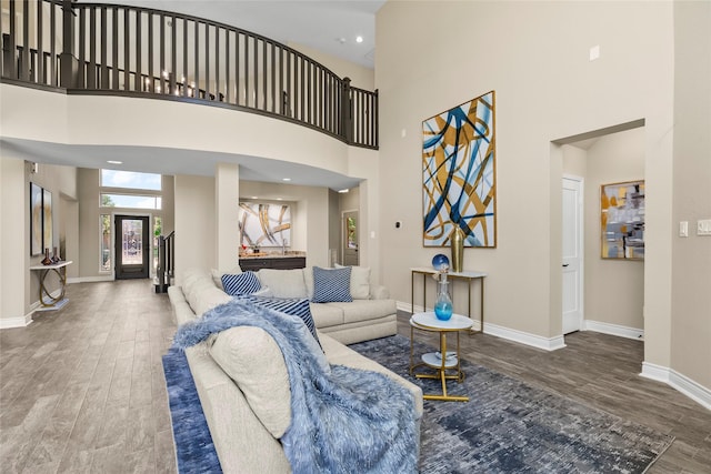 living room featuring hardwood / wood-style flooring and a towering ceiling