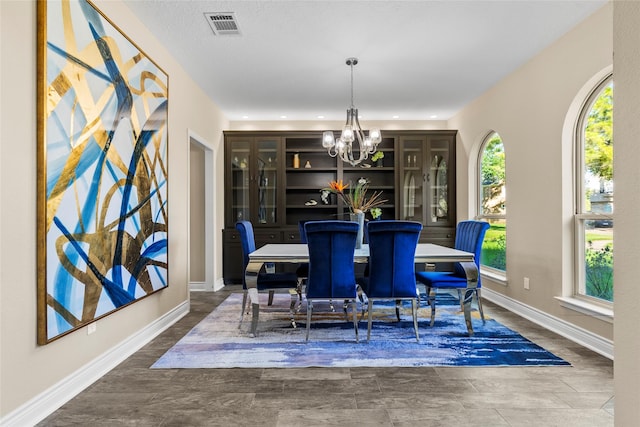 dining room with dark hardwood / wood-style floors and a chandelier