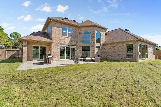 rear view of property featuring a lawn, a patio area, and outdoor lounge area