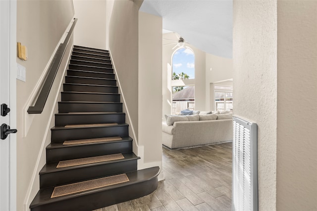 staircase with wood-type flooring and ceiling fan