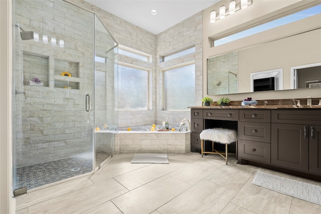 bathroom featuring plus walk in shower, vanity, and tile patterned floors