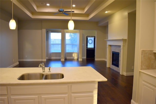 kitchen featuring a high end fireplace, sink, white cabinetry, hanging light fixtures, and ceiling fan