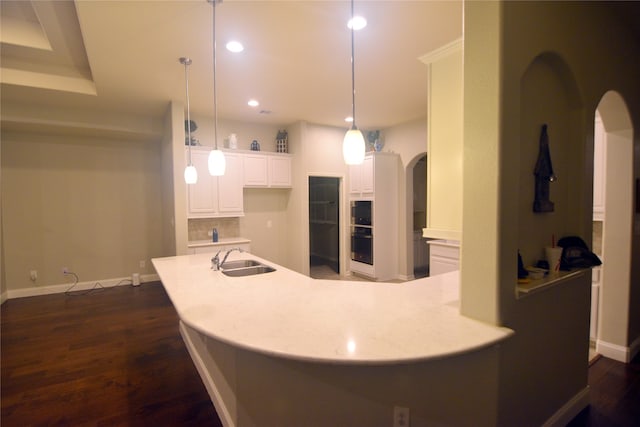 kitchen with pendant lighting, white cabinets, dark hardwood / wood-style floors, and sink