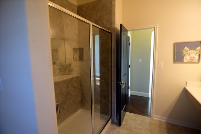 bathroom featuring tile patterned flooring, vanity, and an enclosed shower