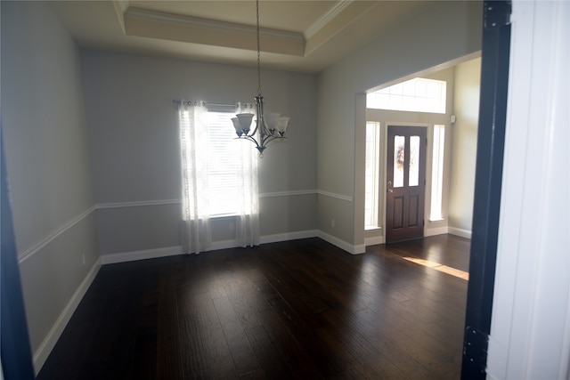 foyer entrance with ornamental molding, a tray ceiling, a chandelier, and dark hardwood / wood-style flooring