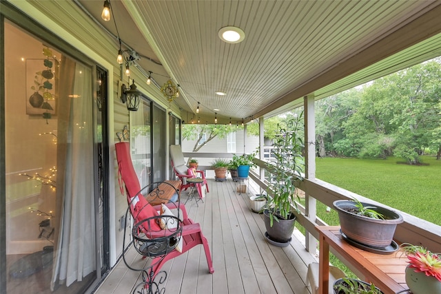 deck with a porch and a lawn