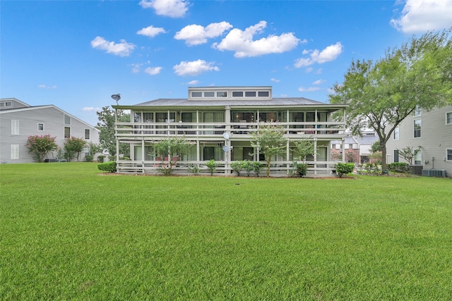 rear view of house with a lawn and central AC unit