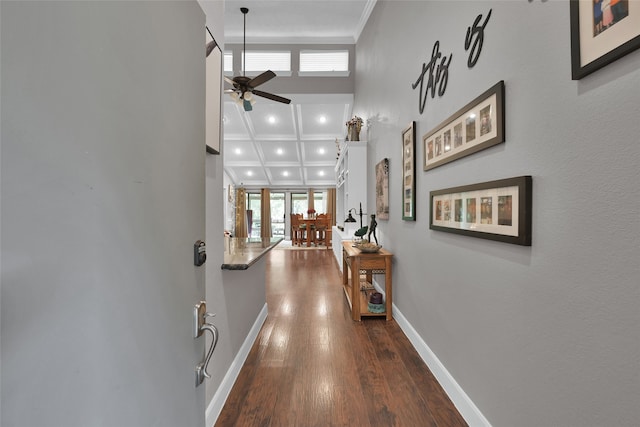 hall with coffered ceiling, a wealth of natural light, hardwood / wood-style flooring, and ornamental molding