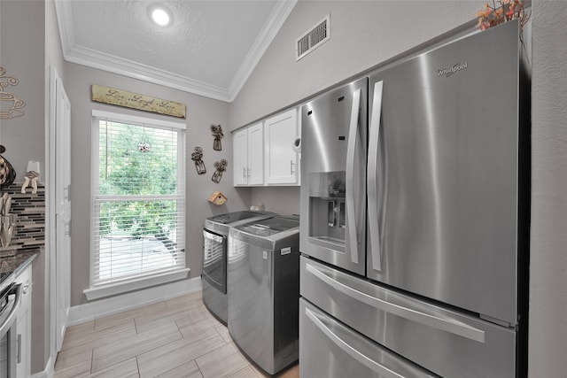 laundry room with cabinets, crown molding, washer and clothes dryer, and a textured ceiling