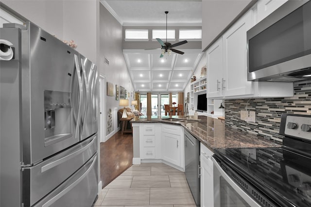 kitchen featuring light hardwood / wood-style floors, stainless steel appliances, kitchen peninsula, white cabinetry, and ceiling fan