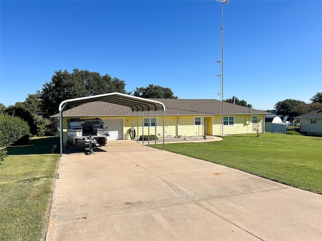 ranch-style house featuring an outbuilding, a front yard, a carport, and a garage