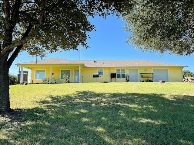 back of property featuring a yard and a garage