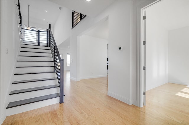 stairs with recessed lighting, baseboards, and wood finished floors