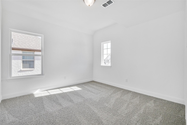 spare room with carpet flooring, baseboards, and visible vents