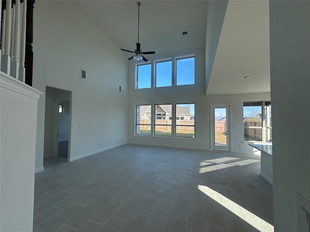 unfurnished living room with visible vents, baseboards, and ceiling fan