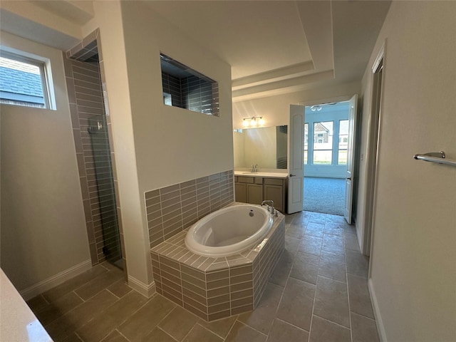 bathroom featuring baseboards, a garden tub, vanity, and a tile shower