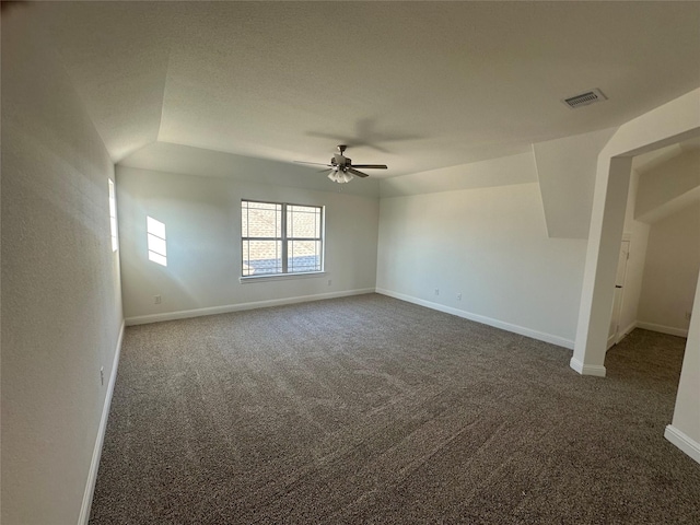 carpeted spare room with baseboards, visible vents, and ceiling fan