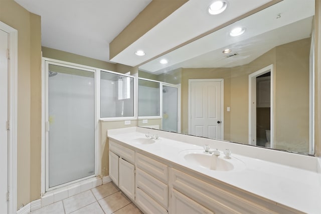 bathroom featuring tile patterned floors, double vanity, a stall shower, and a sink