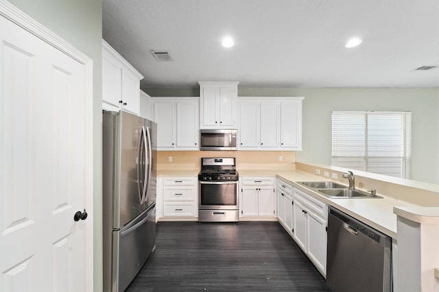 kitchen featuring visible vents, a peninsula, a sink, stainless steel appliances, and light countertops