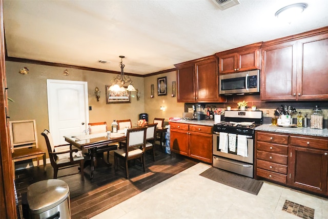 kitchen with decorative light fixtures, light hardwood / wood-style flooring, a notable chandelier, crown molding, and stainless steel appliances