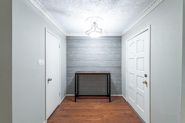 interior space featuring crown molding, dark hardwood / wood-style floors, and a textured ceiling