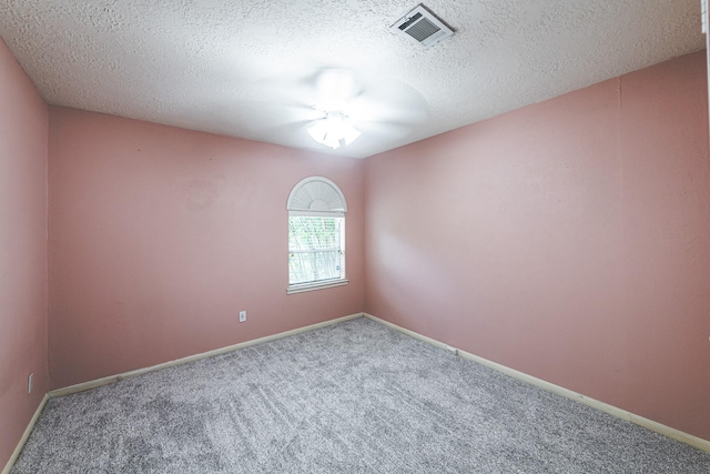 unfurnished room with ceiling fan, carpet flooring, and a textured ceiling