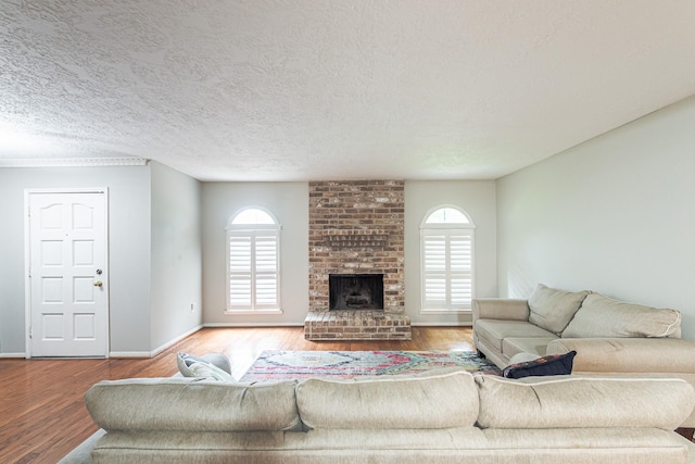 living room featuring a fireplace, a wealth of natural light, hardwood / wood-style floors, and a textured ceiling