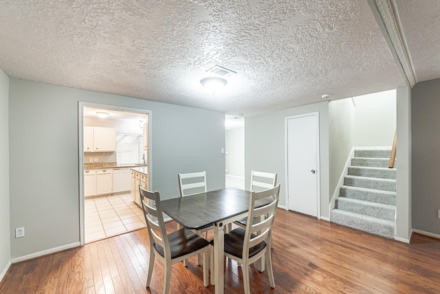 dining room featuring light hardwood / wood-style floors and a textured ceiling