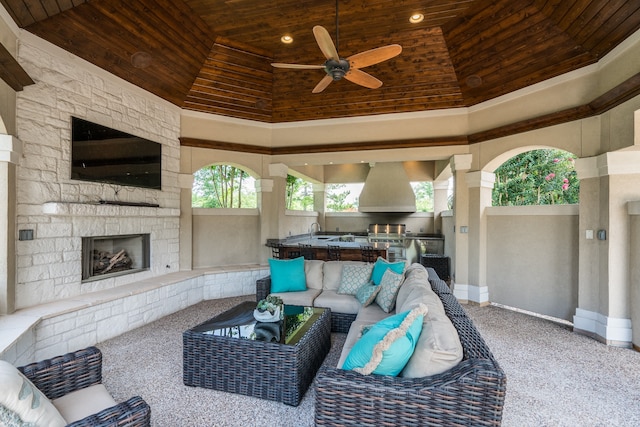 carpeted living room with ceiling fan, sink, wooden ceiling, and a fireplace