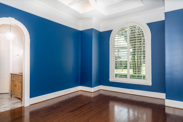 empty room featuring crown molding, hardwood / wood-style floors, and an inviting chandelier