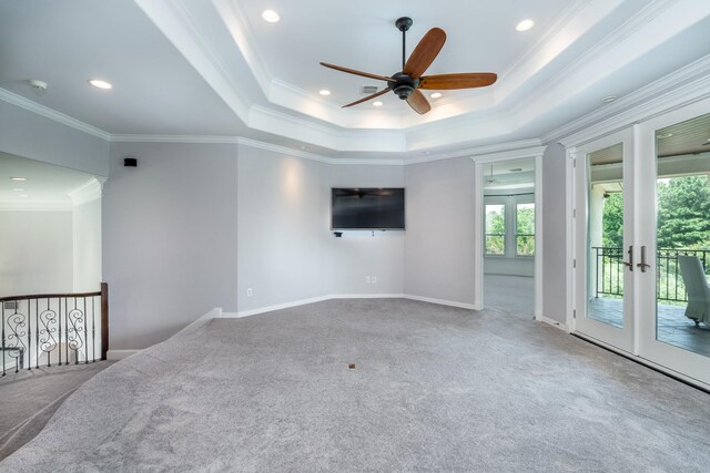 carpeted empty room with crown molding, ceiling fan, a tray ceiling, and french doors