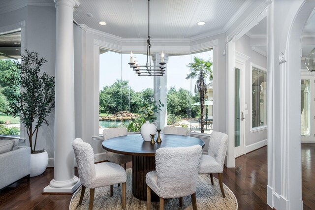 dining space featuring crown molding, dark hardwood / wood-style floors, decorative columns, and a notable chandelier