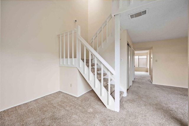 stairway featuring carpet