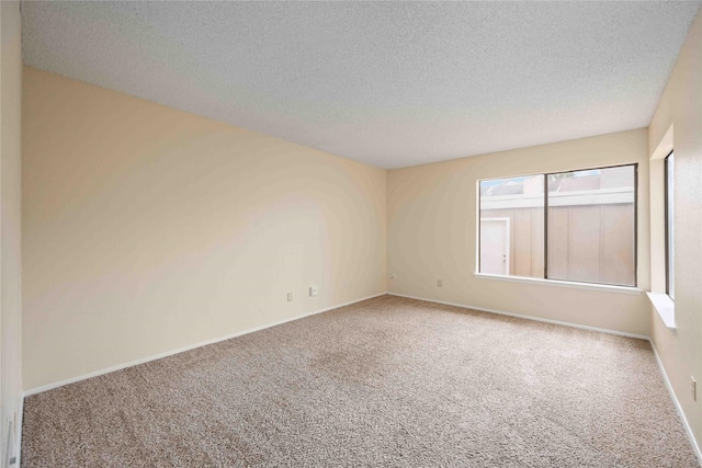 spare room featuring carpet flooring and a textured ceiling