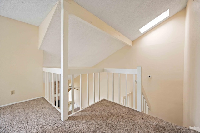 additional living space with carpet flooring, vaulted ceiling with beams, and a textured ceiling