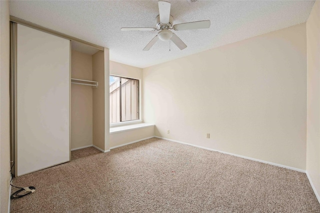 unfurnished bedroom featuring a textured ceiling, carpet floors, a closet, and ceiling fan