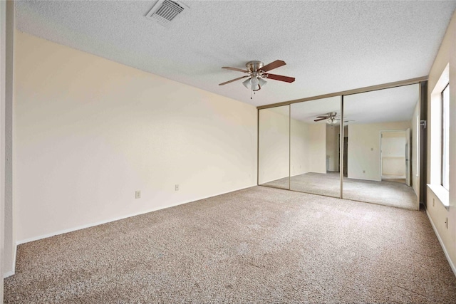 unfurnished bedroom with ceiling fan, carpet floors, and a textured ceiling