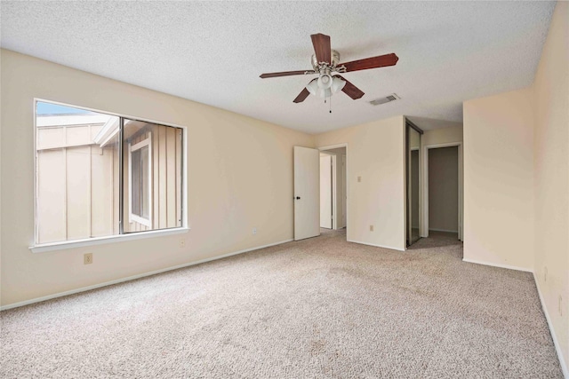 spare room with carpet, ceiling fan, and a textured ceiling