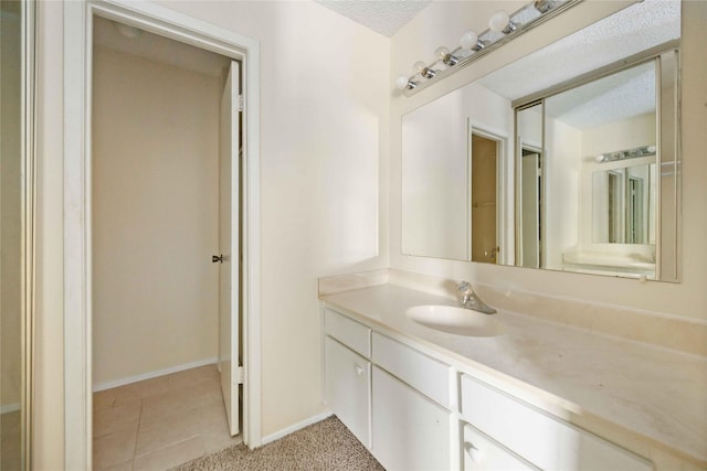 bathroom featuring tile patterned floors, vanity, and a textured ceiling