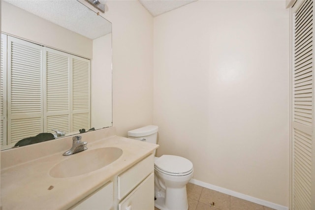 bathroom featuring toilet, a textured ceiling, vanity, and tile patterned floors