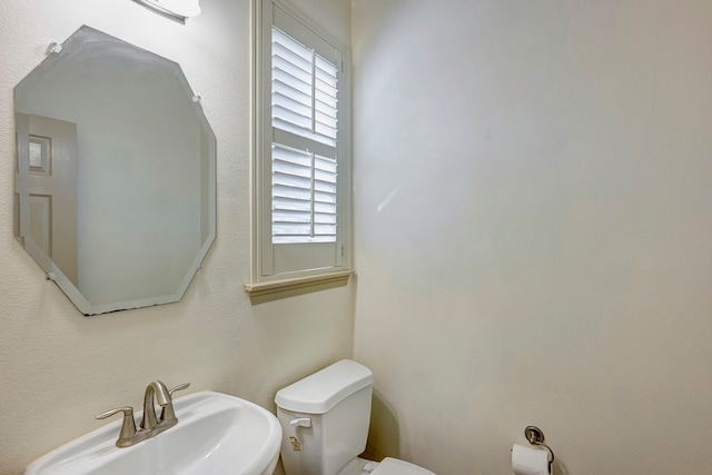 bathroom featuring a healthy amount of sunlight, toilet, and sink