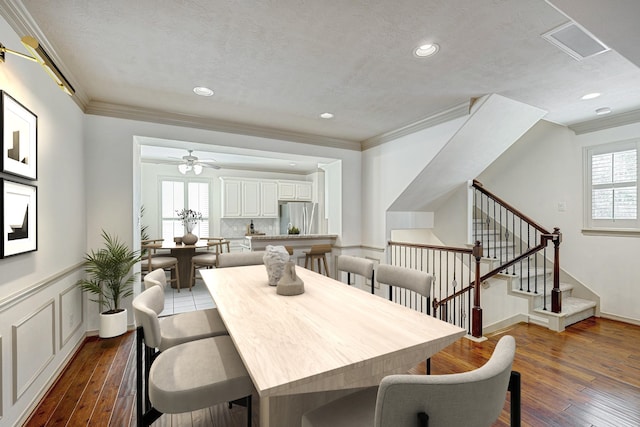 dining space with ceiling fan, a wealth of natural light, dark hardwood / wood-style flooring, and crown molding