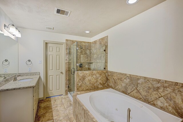 bathroom featuring separate shower and tub, a textured ceiling, and vanity