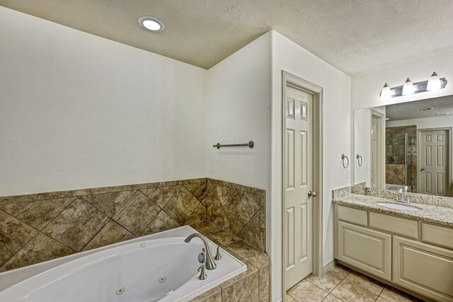 bathroom with vanity, a textured ceiling, plus walk in shower, and tile patterned floors