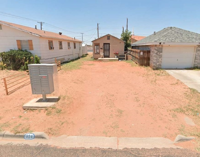 view of yard featuring a garage and mail boxes