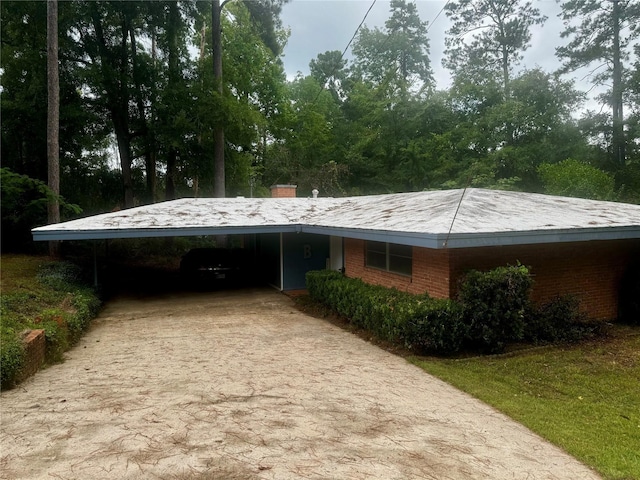 1206 Woodland Park Ave, Jasper, TX 75951 - view of side of property featuring an attached carport, brick siding, concrete driveway, and a chimney