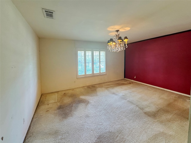 carpeted spare room featuring a chandelier