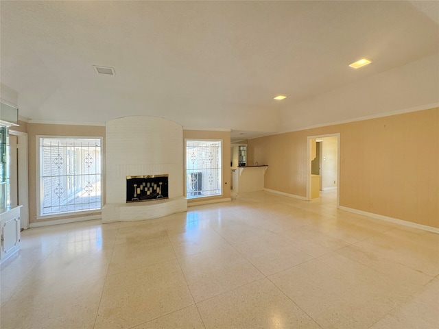 unfurnished living room featuring plenty of natural light and a brick fireplace