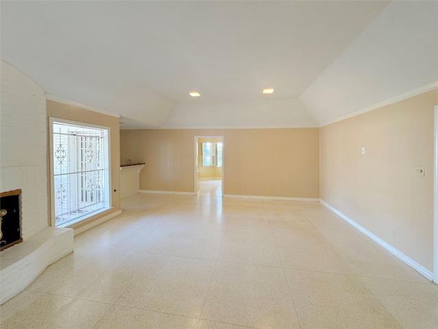 unfurnished living room with lofted ceiling, crown molding, and a fireplace